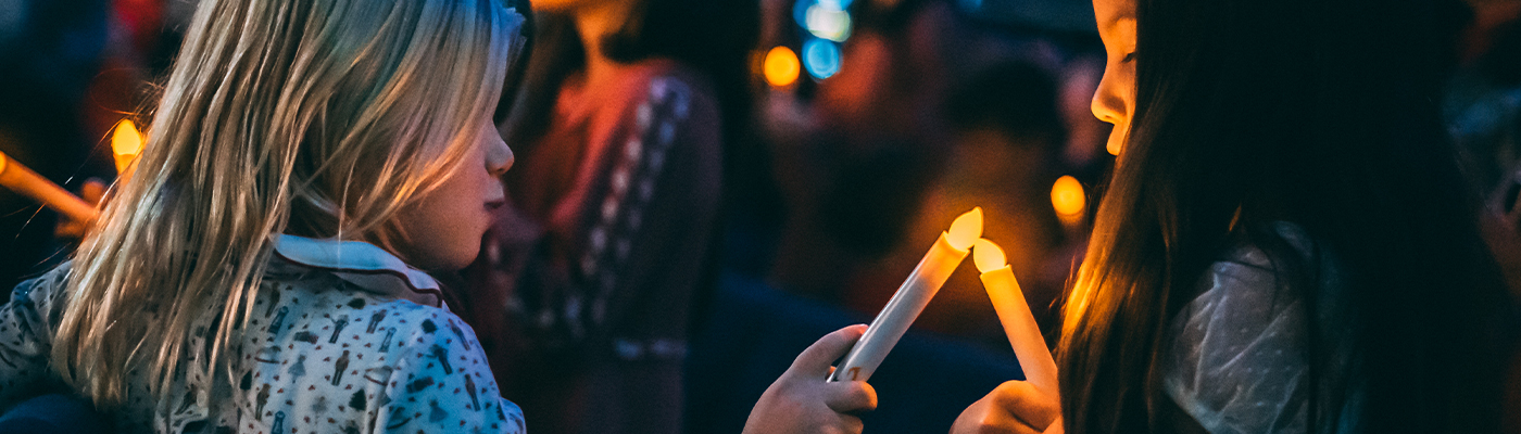 Children lighting Christmas candles. Adoption and the family of God.
